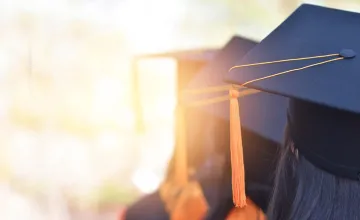 Row of students at a graduation wearing caps, Leading Research Universities Report, December 4, 2023
