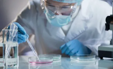 scientist carefully carrying matured cell to another plate, conducting research