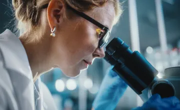 researcher looking into a microscope