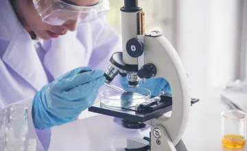 researcher-looking-into-microscope