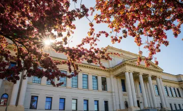 University building in the springtime next to blooming cherry trees