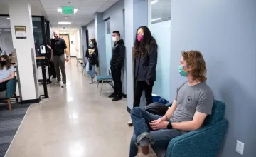 CU Boulder students wait in a campus building