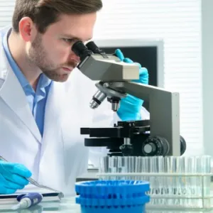Scientist looking through microscope