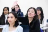 Students in a classroom, one student raising her hand