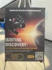 A poster that reads "Igniting Discovery: How NASA Funding Advances American Science." The poster features a spacecraft orbiting Earth.