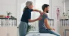 Physical therapist treats patient's shoulder. 