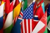 Flags of different countries, with the U.S. flag in focus and the others surrounding it. 