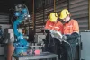 Technicians Programming Industrial Robot Arm