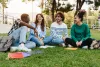 A group of students sitting on a lawn.