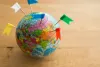 A globe with flags sticking out of it.