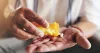 A patient pouring pills out of a prescription medication bottle.