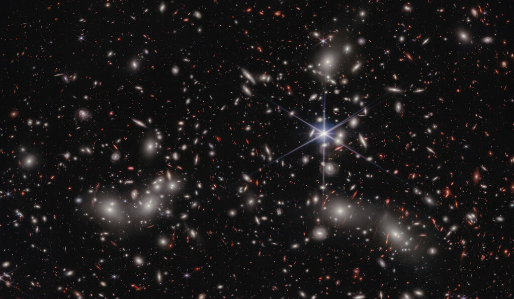 "Astronomers take a deeper, detailed look at a distant galaxy ‘megacluster’; A foreground star in our own galaxy, to the right of the image center, displays Webb’s distinctive diffraction spikes. Bright white sources surrounded by a hazy glow are the galaxies of Pandora’s Cluster"