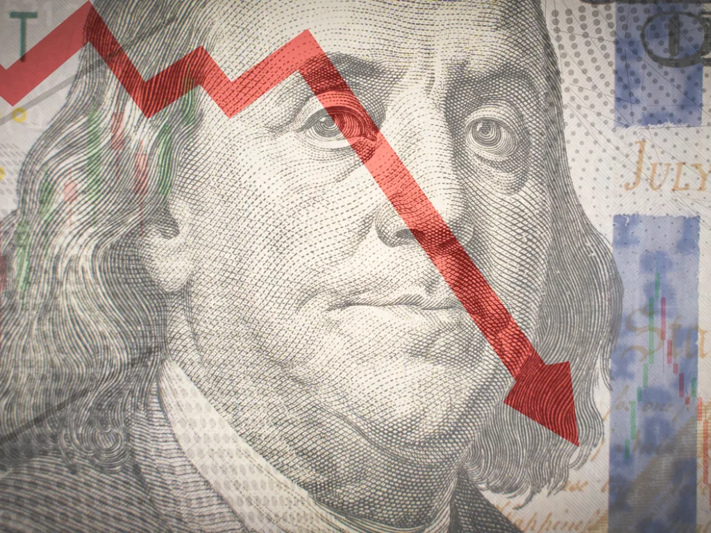 One hundred dollar bill with downward sloping red stock chart arrow.
