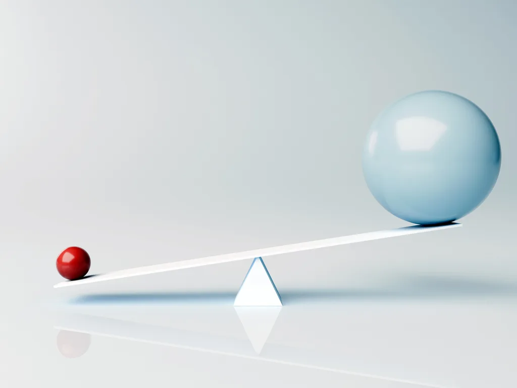 Small red sphere outweighs large blue sphere on seesaw, less is more, balance, power of simplicity - 3d render